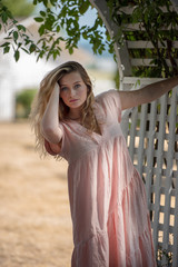 Young blonde teenager modeling outside in summer in sunshine