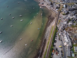 Aerial view, Drone top down panorama over buildings, railway line, road, beach and old town of Barmouth, Wales