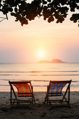 Loungers at the seaside at amazing sunset.
