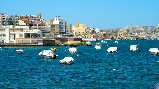 BUGIBBA, MALTA - JUNE 14, 2018: The moored boats in fishing harbor of resort, stretching along  St Paul's Bay, on June 14 in Bugibba.