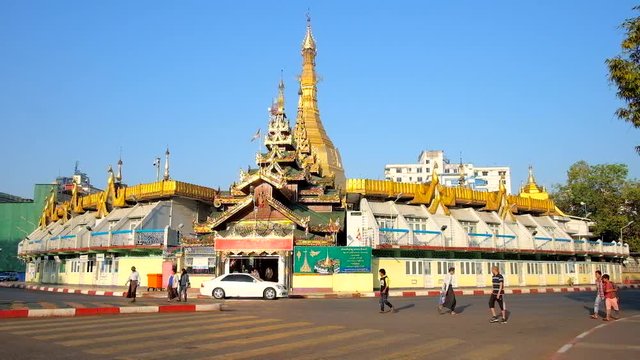 YANGON, MYANMAR - FEBRUARY 17, 2018: Panorama of the golden Sule Pagoda, surrounded by market stores and wide automobile road, on February 17 in Yangon.