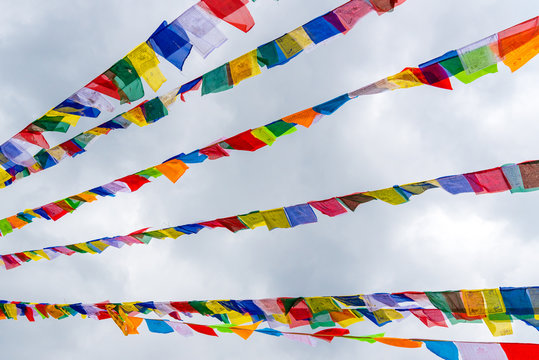 Traditional buddhist prayer flags over blue sky background