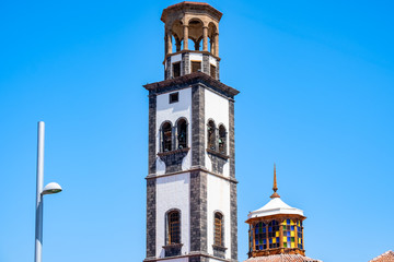 Fototapeta na wymiar Neu und Alt - der Turm der Iglesia de la Concepción daneben moderne Geschäftshäuser.