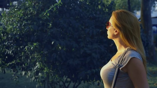 portrait of a young blue-eyed woman standing in a park on a mall. 4. Slow-motion shooting.
