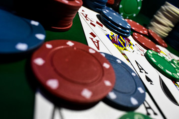 Poker Chips and playing cards on a green felt poker table