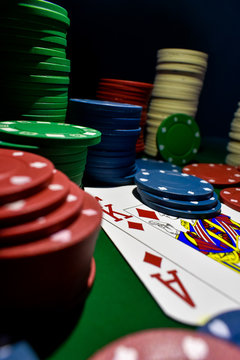 Poker Chips and playing cards on a green felt poker table