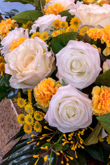 Close up of fake white and yellow roses bouquet.