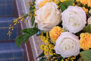 Close up of fake white and yellow roses bouquet.