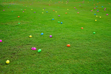 An Easter egg hunt with colorful plastic eggs on a green lawn