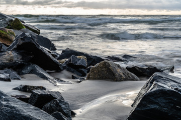 Rockwall in Ocean With Crashing Water at Sunrise Landscape