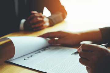 Business people negotiating a contract between two colleagues
