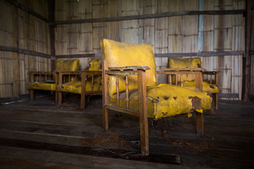 obsolete old yellow leather chair in abondon house
