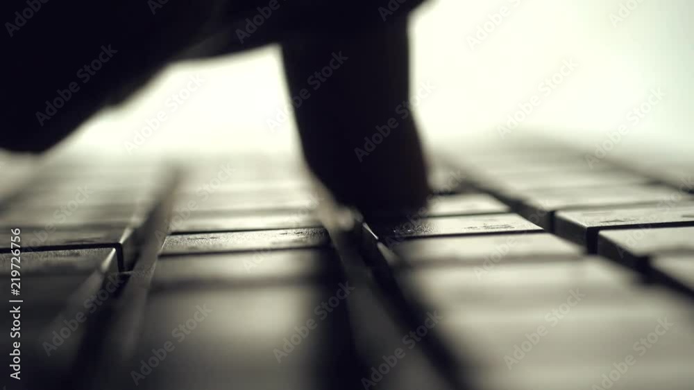 Poster Man typing on computer keyboard. backlit with shallow depth of field. Closeup