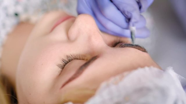 Close-up high angle cosmetician at working eyebrow permanent makeup or microblading at beauty salon