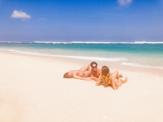 Friends enjoying on a sandy tropical ocean / sea beach.