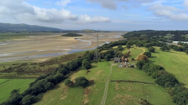 Aerial view, pan move. Drone panorama of Penrhyndeudraeth town and bay during low tide in Wales
