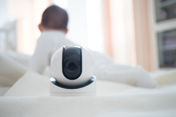 Baby monitor camera with blurred baby background for text space. concept of baby safty