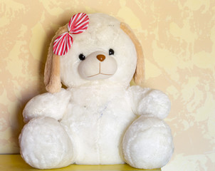 sits a furry toy white dog