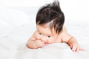 Asian baby girl with hand in mouth