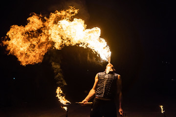 Fire show artist breathe fire in the dark