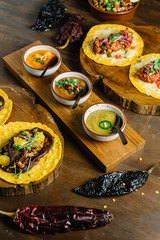 Grilled Chicken and Foie Gras Tacos served on wooden chopping board with different sauces and Mexican dried chili.