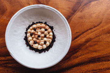 Creative dessert: Thin cream biscuit topping with cream, cocoa powder and chocolate crumble.  