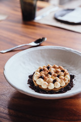 Creative dessert: Thin cream biscuit topping with cream, cocoa powder and chocolate crumble.  