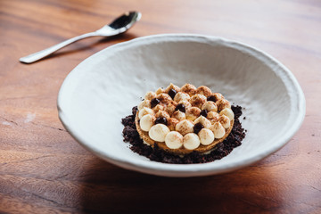 Creative dessert: Thin cream biscuit topping with cream, cocoa powder and chocolate crumble.  