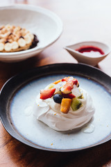 Meringue topping with fresh fruits including strawberry, mango, kiwi, blueberry and common fig served with sour fruit sauce.