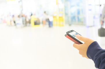 The tourist man use the mobile phone for search and update status on his social media in the terminal for vacation. copy space background.