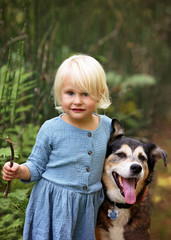 Cute Little Toddler Girl Playing Outside with her Pet Dog in the Forest