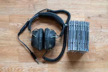 Old vintage headphones beside some CDs