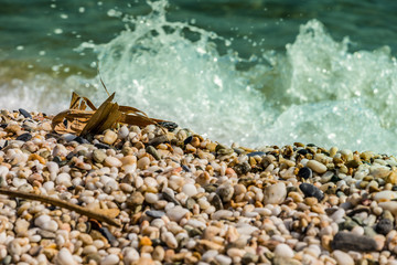 Waves of the blue sea crashing onto a pebble beach in Maronia, Rodopi, Greece
