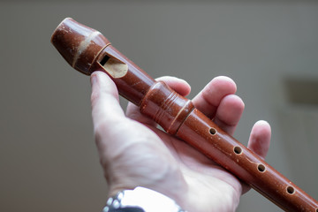 Brown wooden flute holding in the hand of a man © Markus