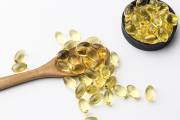 Assorted pharmaceutical medicine pills, tablets and capsules on wooden spoon