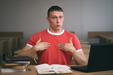 The student is sitting at the table and is looking for excuses for not being ready for the lesson.