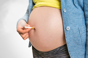 Pregnant woman with cigarette - smoking addiction concept