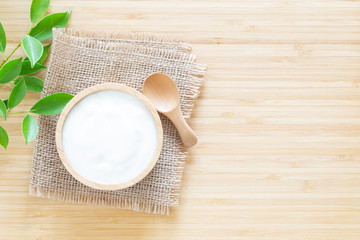 Yogurt in wood bowl on white wooden table Healthy food concept ,top view and copy space