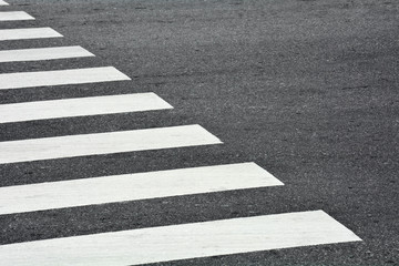 Zebra crosswalk on a asphalt road - closeup background - obrazy, fototapety, plakaty