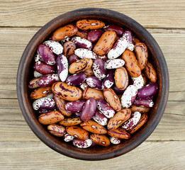 Haricot beans in bowl on wooden background