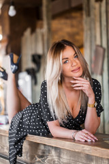 Close-up portrait of a beautiful cute blonde woman lying on a rack indoors