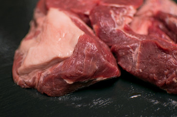 A piece of raw pork on a black background.