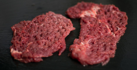 Raw pork chop on a dark background.
