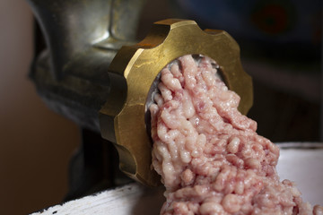 A golden home meat grinder grinds the pieces of meat to minced meat. Preparation of meat for...
