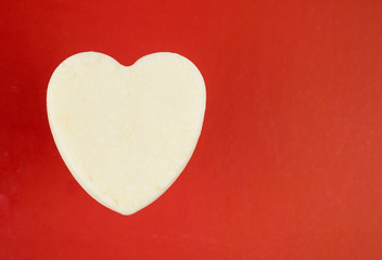 Fototapeta premium White heart from soap on a red background.