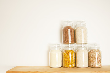Various uncooked cereals, grains, pasta, bukwheat, rice, oat meals. Healthy cooking in glass jars...