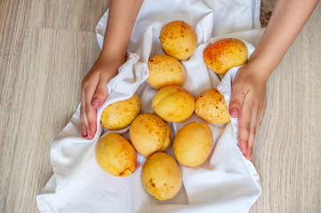 Apricots in human hands on light fabric