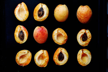 Halves of fruits of an apricot against a dark background