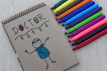 step by step draw doctor with colorful felt-pens and clock on the wooden table for school or kindergarten activity time or education concept.creative ideas for child development.back to school concept