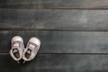 Baby boy shoes on blue wooden background